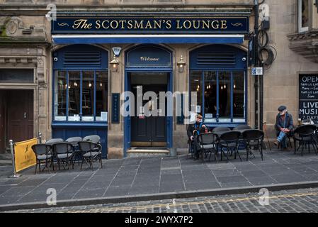 Zwei ältere Männer sitzen vor der Scotsman's Lounge in der Cockburn Street in Edinburghs Altstadt. Stockfoto