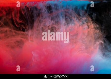 Wolken von rotem und blauem Rauch auf schwarzem Hintergrund, Wolken von Farbe im Wasser, Aquarium, abstrakter Hintergrund, Textur Stockfoto