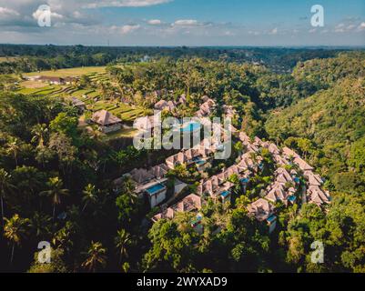 Blick aus der Vogelperspektive auf das Luxushotel mit Strohdach-Villen und Pools im tropischen Dschungel. Luxuriöse Villa, Pavillon im Wald, Ubud, Bali. Stockfoto