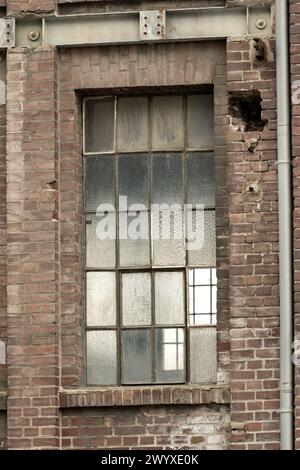 Details eines alten Industriegebäudes, Backsteinmauer und Fenster, ca. 100 Jahre alt Stockfoto