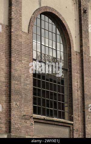 Details eines alten Industriegebäudes, Backsteinmauer und Fenster, ca. 100 Jahre alt Stockfoto