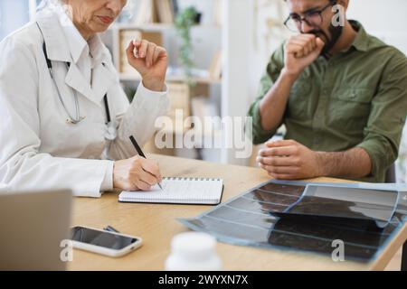 Hausärztin kommuniziert mit jungen Hustpatienten. Stockfoto