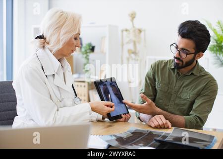 Ängstlicher Mann gekleidet, aufmerksam auf ärztliche Anweisungen zu hören. Stockfoto