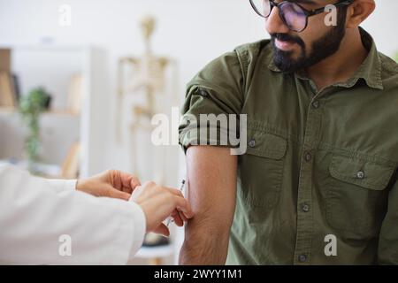 Zugeschnittene Ansicht der Hand, die eine Injektion gibt, um die Immunität bei jungen Patienten zu erhöhen. Stockfoto