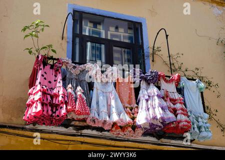 Traditionelle Flamenco-Kostüme hängen an der Balkonfassade des spanischen andalusischen Hauses in Málaga, Spanien. Stockfoto