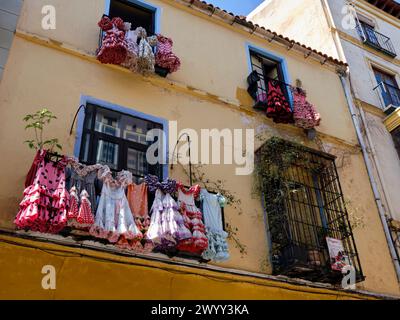 Traditionelle Flamenco-Kostüme hängen an der Balkonfassade des spanischen andalusischen Hauses in Málaga, Spanien. Stockfoto