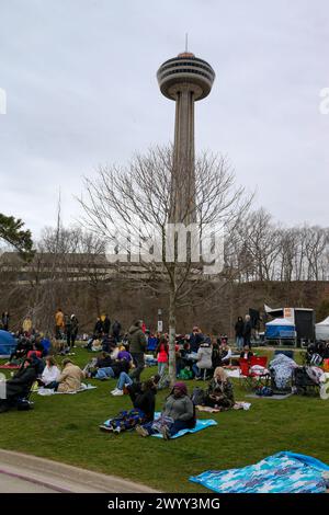 Niagarafälle, Kanada. April 2024. Der Queen Victoria Park in den Niagarafällen Ontario ist ein Treffpunkt für die Sonnenfinsternis 2024. Die Niagarafälle erwarten mehr als eine Million Menschen, um die Sonnenfinsternis zu sehen. Leute warten auf die Sonnenfinsternis vor dem Skyline-Turm. Quelle: Luke Durda/Alamy Live News Stockfoto