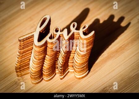 Wortliebe in Holz auf Holzbrett mit Schatten Stockfoto