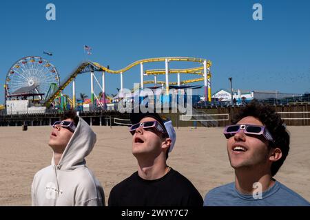 Massimo Soto, Kyle Lotke und Casey Bajec beobachten am Montag, den 8. April 2024, eine partielle Sonnenfinsternis in Santa Monica, Kalifornien. Stockfoto