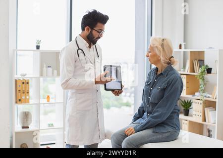 Bärtiger Mann im Labormantel mit Tablette mit MRT-Scan. Stockfoto