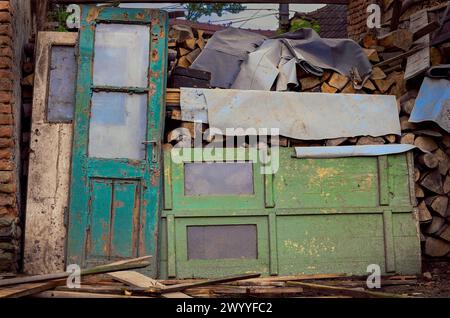 Holztüren mit Glasfenstern wurden aufgegeben und mit gerissener Farbe und verfaultem Holz zerstört Stockfoto
