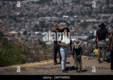 Mexiko Stadt, Mexiko. April 2024. Die Menschen beobachten die Sonnenfinsternis im Stadtteil Cerro de la Estrella in Iztapalapa. Millionen Menschen in Mexiko, den USA und Kanada erlebten am Montag eine totale Sonnenfinsternis. Ein solches himmlisches Spektakel tritt auf, wenn der Mond zwischen Sonne und Erde vorbeizieht und die Sonne vollständig bedeckt. Quelle: Jair Cabrera Torres/dpa/Alamy Live News Stockfoto