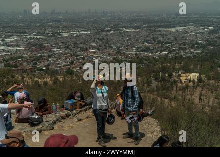 Mexiko Stadt, Mexiko. April 2024. Die Menschen beobachten die Sonnenfinsternis im Stadtteil Cerro de la Estrella in Iztapalapa. Millionen Menschen in Mexiko, den USA und Kanada erlebten am Montag eine totale Sonnenfinsternis. Ein solches himmlisches Spektakel tritt auf, wenn der Mond zwischen Sonne und Erde vorbeizieht und die Sonne vollständig bedeckt. Quelle: Jair Cabrera Torres/dpa/Alamy Live News Stockfoto