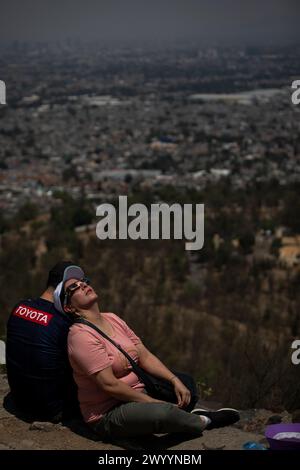 Mexiko Stadt, Mexiko. April 2024. Eine Frau benutzt eine Schutzbrille, um die Sonnenfinsternis vom Pirámide Cerro de la Estrella aus zu sehen. Millionen Menschen in Mexiko, den USA und Kanada erlebten am Montag eine totale Sonnenfinsternis. Ein solches himmlisches Spektakel tritt auf, wenn der Mond zwischen Sonne und Erde vorbeizieht und die Sonne vollständig bedeckt. Quelle: Jair Cabrera Torres/dpa/Alamy Live News Stockfoto