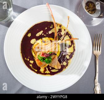 Blick von oben auf gebackene Lammrippchen in Weinsauce mit Auberginen und getrocknetem Hibiskus Stockfoto