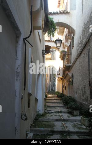 Enge Gasse zwischen alten Gebäuden im historischen Zentrum von Minturno, Italien Stockfoto