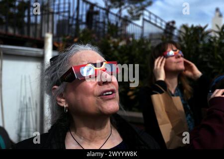 New York City, New York, Usa. April 2024. Die Menschen begeben sich auf ein Dach im Chelsea-Teil von Manhattan in New York City, um die Sonnenfinsternis zu sehen, die heute über Nordamerika und Kanada zu sehen war. Quelle: Adam Stoltman/Alamy Live News Stockfoto