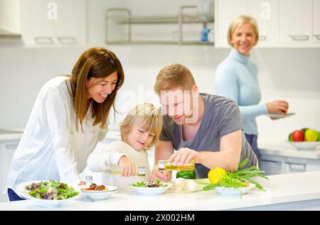 Familie in der Küche. Drei Generationen. Gesunde Ernährung. Gesundes Wachstum. Gemüsesalat machen. Stockfoto