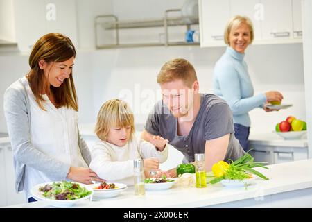 Familie in der Küche. Drei Generationen. Gesunde Ernährung. Gesundes Wachstum. Gemüsesalat machen. Stockfoto