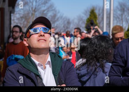Montreal, CA, 8. April 2024 - Mann mit Sonnenfinsternis-Brille, schaut auf, um 2024 Sonnenfinsternis zu sehen Stockfoto