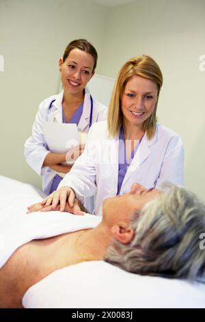 Arzt und Krankenschwester mit Patient im Krankenhauszimmer. Krankenhaus Policlinica Gipuzkoa, San Sebastian, Donostia, Euskadi, Spanien. Stockfoto