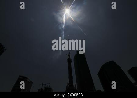 Mazatlan, Mexiko. April 2024. Die Sonne wird während der Großen Nordamerikanischen Sonnenfinsternis durch das Angel de la Independencia Monument gesehen. Große Menschenmassen versammeln den Angel de la Independencia, um eine teilweise Sonnenfinsternis zu erleben. Am 8. April 2024 in Mexiko-Stadt. (Foto: Ian Robles/Eyepix Group/SIPA USA) Credit: SIPA USA/Alamy Live News Stockfoto