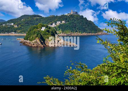 Vista de la Bahia de La Concha desde la Bateria de las Damas, la Isla Santa Clara con la Casa del Faro donde se encuentra la obra Hondalea de la escultora Cristina Iglesias, Al fondo el Monte Igeldo, Donostia, San Sebastian, Ciudad cosmopolita de 187,000 habitantes, destaca por su gastronomía, playas urbanas y edificios inspirados en la arquitectura parisina, Gipuzkoa, Baskenland, Spanien, Europa. Stockfoto