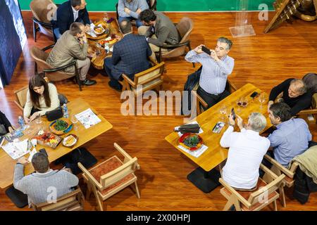 Foto einer Gruppe von Menschen, alten Männern, die Fotos in einem serbischen Restaurant machen, während andere Menschen in belgrad, serbien, essen. Stockfoto