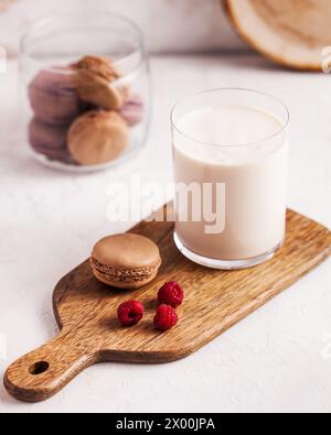 Frischer Milchdrink ryazhenka in einem Glas mit zarten Nudeln und frischen Himbeeren Stockfoto