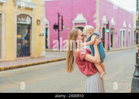 Mutter und Baby Sohn Touristen erkunden die lebhaften Straßen von Valladolid, Mexiko, und tauchen ein in die reiche Kultur und farbenfrohe Architektur von Stockfoto