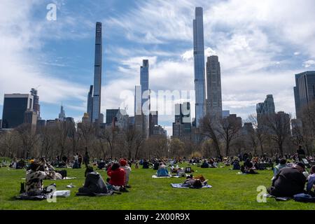 New York, Usa. April 2024. Menschen genießen die Sonnenfinsternis mit Blick auf den Wolkenkratzer nach Süden. New Yorker versammelten sich im Central Park, um die Sonnenfinsternis zu sehen. Die Sonne wurde vom Mond um 90 % verdeckt, nur schüchtern vor der Totalität. Die letzte Sonnenfinsternis in New York City war 2017 und erreichte 70 %. Die nächste Sonnenfinsternis für die Stadt wird im Jahr 2045 mit nur 50 % sein. Die New Yorker müssen bis Mai 2079 warten. Quelle: SOPA Images Limited/Alamy Live News Stockfoto