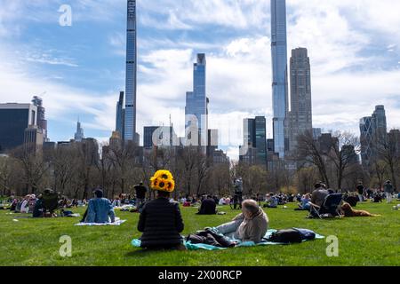 New York, Usa. April 2024. Menschen genießen die Sonnenfinsternis mit Blick auf den Wolkenkratzer nach Süden. New Yorker versammelten sich im Central Park, um die Sonnenfinsternis zu sehen. Die Sonne wurde vom Mond um 90 % verdeckt, nur schüchtern vor der Totalität. Die letzte Sonnenfinsternis in New York City war 2017 und erreichte 70 %. Die nächste Sonnenfinsternis für die Stadt wird im Jahr 2045 mit nur 50 % sein. Die New Yorker müssen bis Mai 2079 warten. Quelle: SOPA Images Limited/Alamy Live News Stockfoto