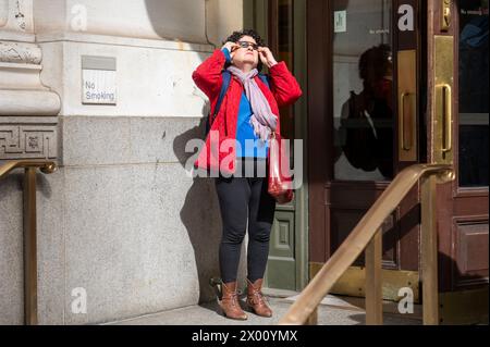 New York, Usa. April 2024. Die Leute beobachten eine teilweise Sonnenfinsternis auf der 5th Avenue am 8. April 2024 in New York City. Mit der ersten Sonnenfinsternis, die seit sieben Jahren Nordamerika durchquerte, war New York City nicht auf dem Weg der Totalität, da nur 90 % der Sonne vom Mond bedeckt waren; die nächste Sonnenfinsternis, die in den Vereinigten Staaten zu sehen ist, wird 2044 sein. Quelle: SOPA Images Limited/Alamy Live News Stockfoto