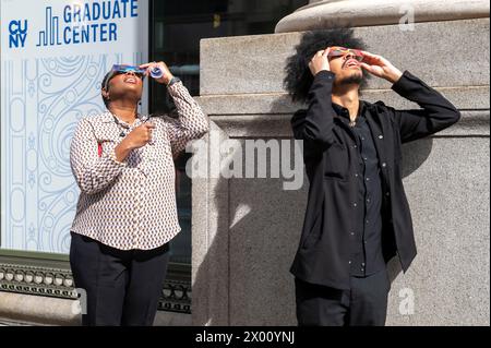 New York, Usa. April 2024. Die Leute beobachten eine teilweise Sonnenfinsternis auf der 5th Avenue am 8. April 2024 in New York City. Mit der ersten Sonnenfinsternis, die seit sieben Jahren Nordamerika durchquerte, war New York City nicht auf dem Weg der Totalität, da nur 90 % der Sonne vom Mond bedeckt waren; die nächste Sonnenfinsternis, die in den Vereinigten Staaten zu sehen ist, wird 2044 sein. Quelle: SOPA Images Limited/Alamy Live News Stockfoto