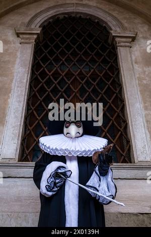 Porträt einer maskierten Person in einem kreativen Medico Della Peste Kostüm, posiert vor dem Palazzo Ducale, um den venezianischen Karneval zu feiern. Stockfoto
