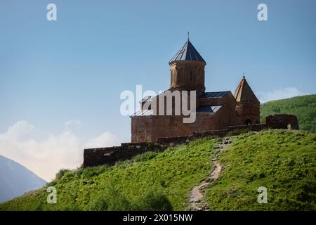 Blick aus der Nähe auf die Heilige Dreifaltigkeitskirche in den Kazbegi Bergen in der Nähe von Stepantsminda Blick auf die Kaukasusberge im Hintergrund Stockfoto