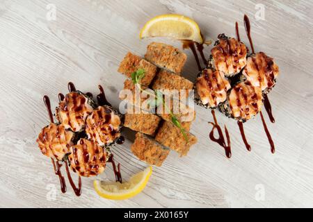 Set aus verschiedenen Sushi-Rollen auf weißem Holzhintergrund. Japanisches Essen. Stockfoto