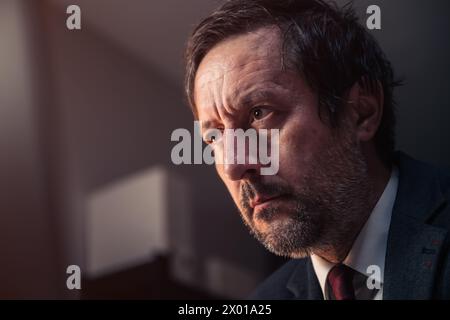 Fokussierter aufmerksamer männlicher Geschäftsmann, der auf Laptop-Bildschirm schaut, selektiver Fokus Stockfoto