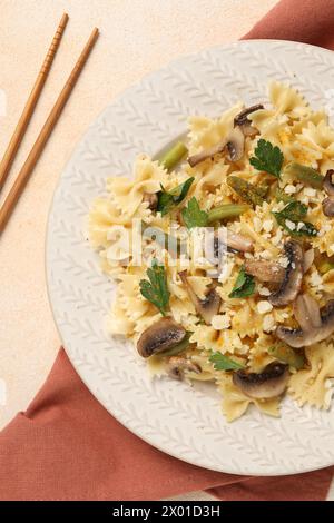 Vegetarische Pasta mit Pilzen, Petersilie, Bohnen und Käse auf orangefarbenem Tisch, Blick von oben Stockfoto