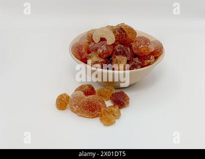 Arabisches Kaugummi, ist ein natürliches Lebensmittelprodukt mit einer breiten Palette von gesundheitlichen Vorteilen. Hohe Menge an Protein und arabischem Ballastgummi im weißen Hintergrund der Schüssel Stockfoto