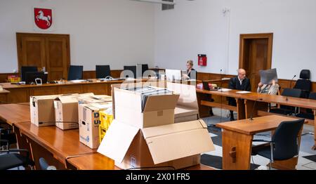 9. April 2024, Niedersachsen, Lüneburg: Die Beklagte (r) sitzt neben ihrem Verteidiger Norbert Lösing (M) im Amtsgericht, während Aktenkisten im Vordergrund stehen. Der Prozess gegen einen Reichsbürger wird vor dem Amtsgericht Lüneburg erneut angeklagt. Der 63-Jährige wurde 2022 zu dreieinhalb Jahren Haft verurteilt. Ihre Strafe könnte nun reduziert werden. Foto: Philipp Schulze/dpa Stockfoto