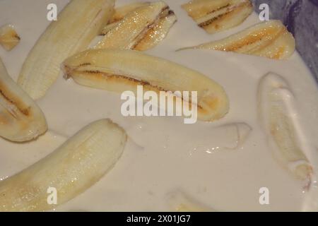 Foto von Bananen, die in heißem Öl frittiert werden, knusprige Bananen in Mehl Stockfoto