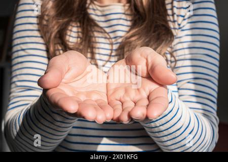 Eine Frau in einem gestreiften Hemd macht Gesten mit ihren Händen Stockfoto