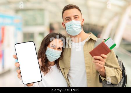 Paare Tragen Masken Mit Pässen Und Leerem Smartphone Am Flughafen Stockfoto