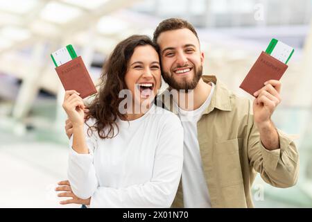 Mann und Frau, die am Flughafen Pässe halten und die Kamera lächeln Stockfoto