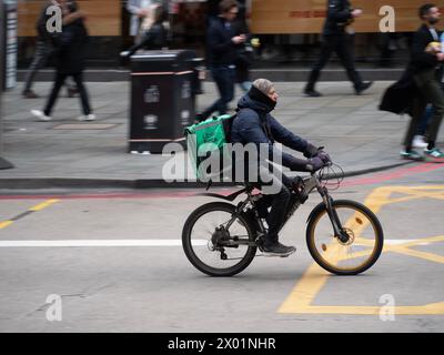 Uber isst Food Delivery Radfahrer in Central London, schläft auf der Bank Liverpool Street Stockfoto