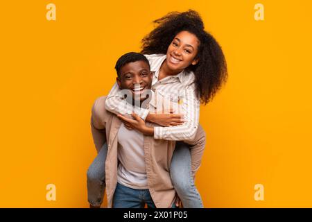 Glückliches Paar, das auf gelbem Hintergrund lacht Stockfoto