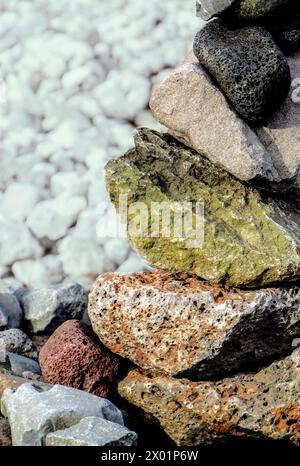 Ein Steinhaufen mit einem grünen Felsen in der Mitte. Die Felsen sind übereinander gestapelt Stockfoto