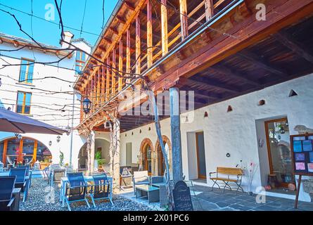 LOCARNO, SCHWEIZ - 26. MÄRZ 2022: Der Innenhof des historischen Hauses mit kleinen Tischen des Restaurants Locarno, Schweiz Stockfoto