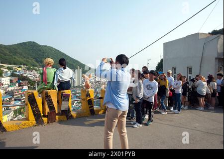 Die Leute machen eine Schlange, um mit der Little Price Statue im Gamcheon Culture Village, einer Stadt von Gamcheon-dong, Saha District in Busan, Südkorea, ein Foto zu machen. Stockfoto